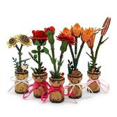 Vijf houten modelbloemen, waaronder roos, zonnebloem, anjer, lelie en tulpen, in potjes met linten.