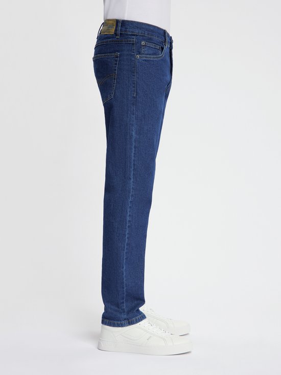 Donkerblauwe spijkerbroek met ritssluiting, zichtbaar vanaf de zijkant.