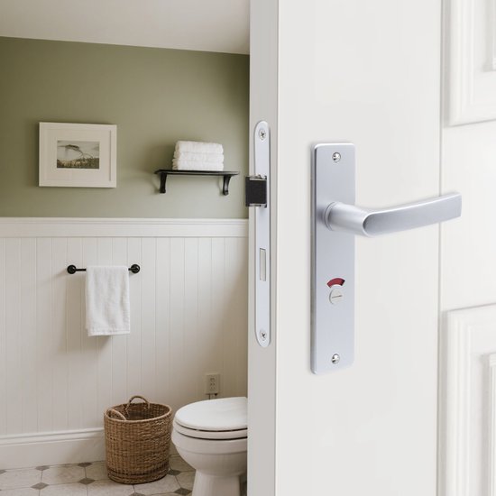 Zilverkleurige deurklink met insteekslot op een witte deur in een badkamer.