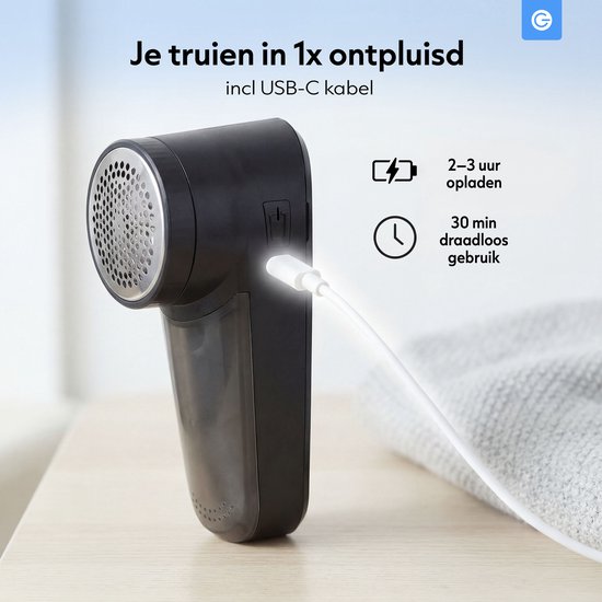 Zwarte pluizenverwijderaar met USB-C kabel, 2-3 uur opladen, 30 min draadloos gebruik.