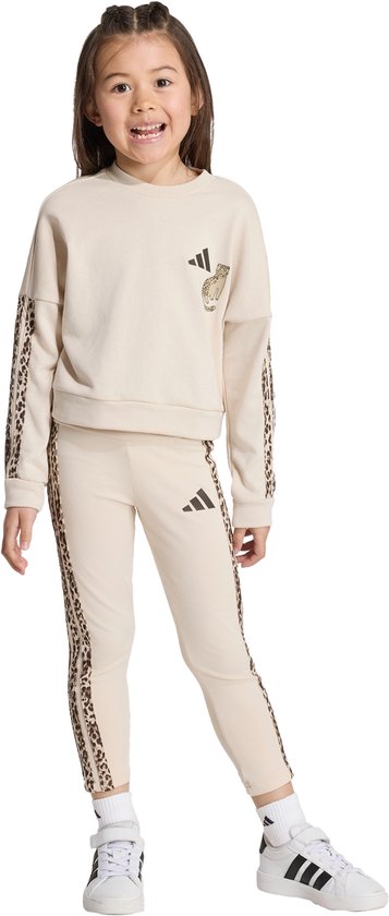 Jeune fille dans un survêtement beige avec imprimé léopard sur les côtés des manches et du pantalon.