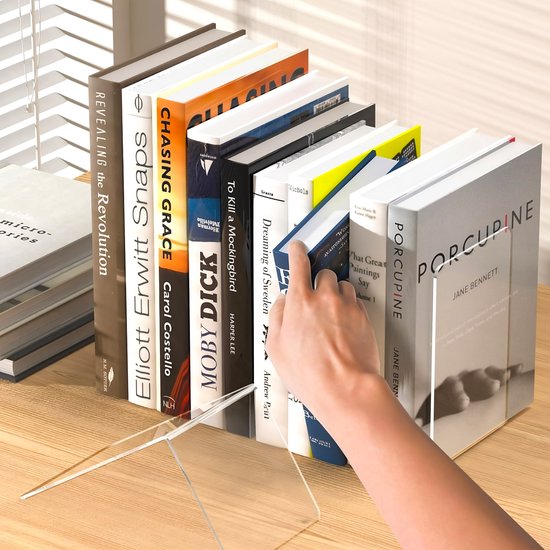 Een hand die een boek tussen transparante boekensteunen plaatst, met een rij boeken op de voorgrond.