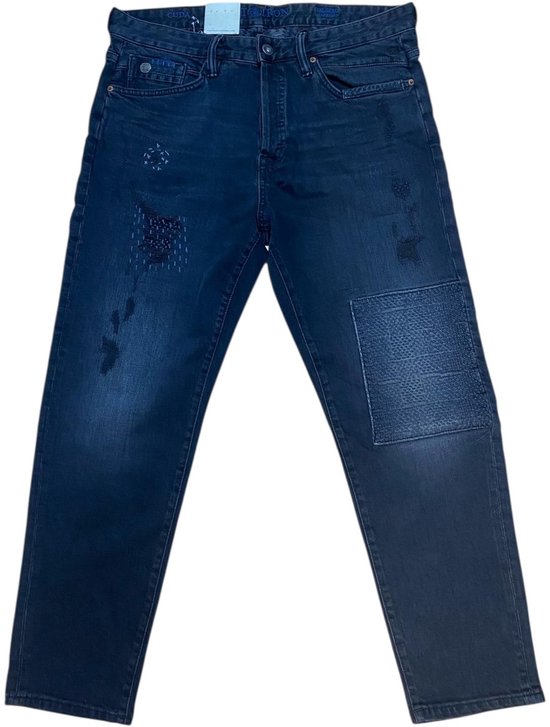 Donkere jeans met een relaxte pasvorm en distressed details, zoals patches en zichtbare naden. Twee steekzakken en twee achterzakken.