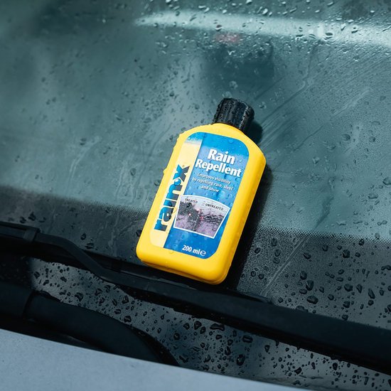 Gele fles Rain-X Regenafstotend op een natte voorruit met ruitenwissers.
