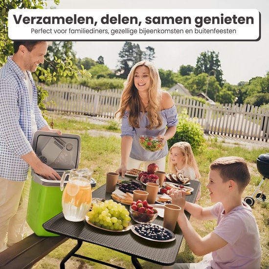 Een familie geniet van een maaltijd aan een zwarte tafel met rotan-look op een tuinfeest.