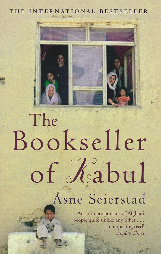 Boek 'The Bookseller of Kabul' van Åsne Seierstad. Cover toont een raam met vrouwen en kinderen, en een jongen zittend op een muur.