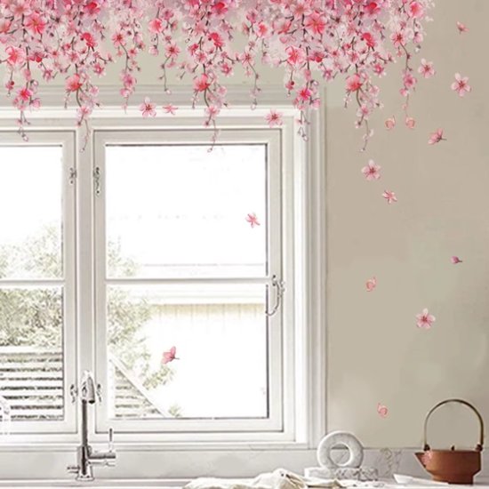 Hangende roze bloesemtakken met losse bloesems en vlinders, decoratie boven een raam.