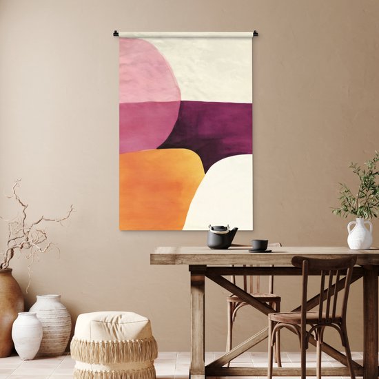 Tapisserie abstraite avec des formes roses, violettes, oranges et crème au-dessus d'une table à manger en bois.