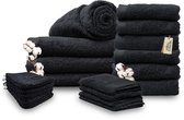 Een stapel zwarte Miss Towels handdoeken in verschillende formaten, met katoentakjes.