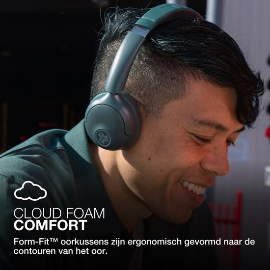 Man met groene JLab GO Lux ANC koptelefoon glimlacht, met tekst 'CLOUD FOAM COMFORT' en icoon.