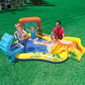 Gezin met kinderen spelen in opblaasbaar dinosaurus zwembad met glijbaan en water.