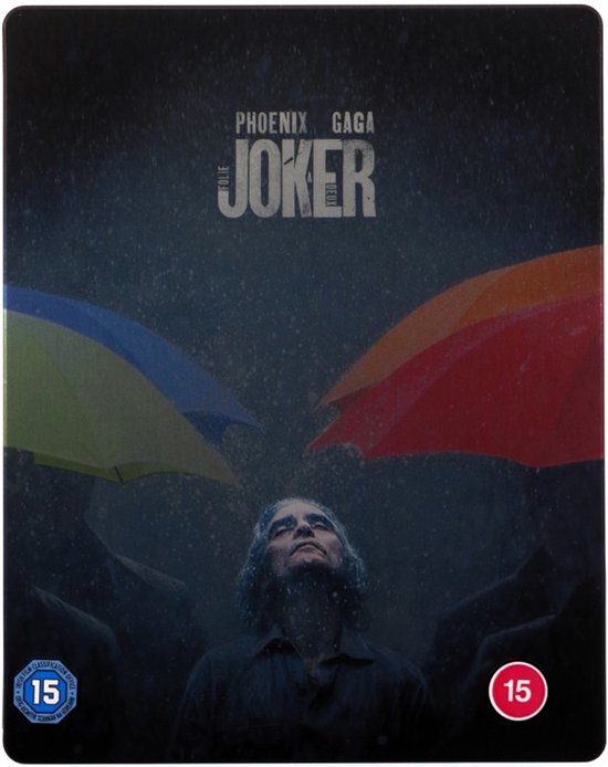 Een man met lang haar, 'The Joker', kijkt omhoog in de regen onder gele, oranje en rode paraplu's.