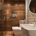 Zelfklevend roestvrijstalen doucherek met diverse toiletartikelen, gemonteerd aan een houten betegelde muur in een badkamer.