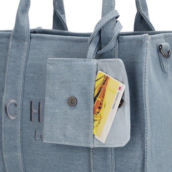 Detail van het klepje van een lichtblauwe denim shopper met een insteekvakje voor een pasje.