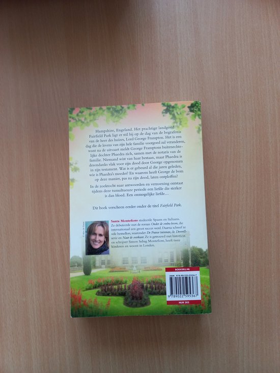 Boekcover met een landhuis en bloemen, de titel "Een liefde in Fairfield Park" en "Santa Montefiore".