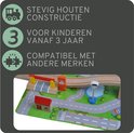 Detail van houten treinbaan met grondplaat, weg, vijver en verkeerslicht.