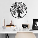 L'arbre de vie en métal noir est suspendu à un mur blanc au-dessus d'un bureau avec un ordinateur portable et une radio.
