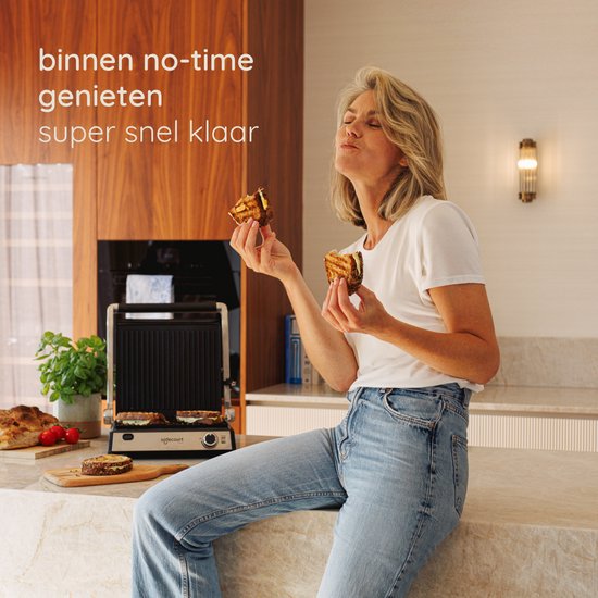Vrouw met een tosti in elke hand, genietend. Ze zit op het aanrecht, naast een Safecourt contactgrill.