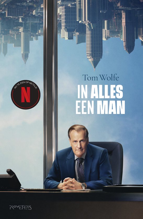Un homme en costume bleu est assis à un bureau, les mains jointes. Une réflexion de ville en arrière-plan.