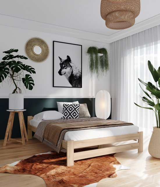 Een tweepersoons bed met een licht houten frame, opgemaakt met bruine en witte kussens en een deken.