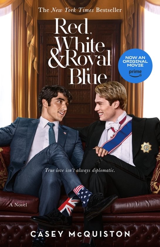 Boekomslag van "Red, White & Royal Blue" met twee mannen die op een bank zitten. De ene man draagt een pak en sokken met de Amerikaanse vlag. De andere man draagt een koninklijk lint.