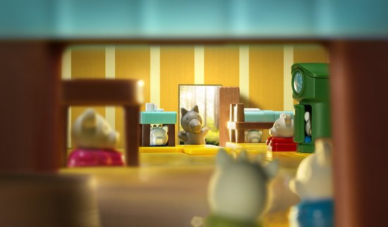 Vu de la perspective d'une pièce de jeu, une scène du jeu 'Le Loup et les 7 Chevreaux Deluxe' avec un loup et des chevreaux.