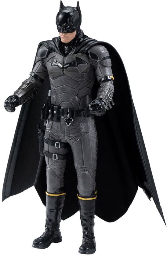 Batman speelfiguur in gedetailleerd grijs pantser met zwarte cape en gele accenten op laarzen.