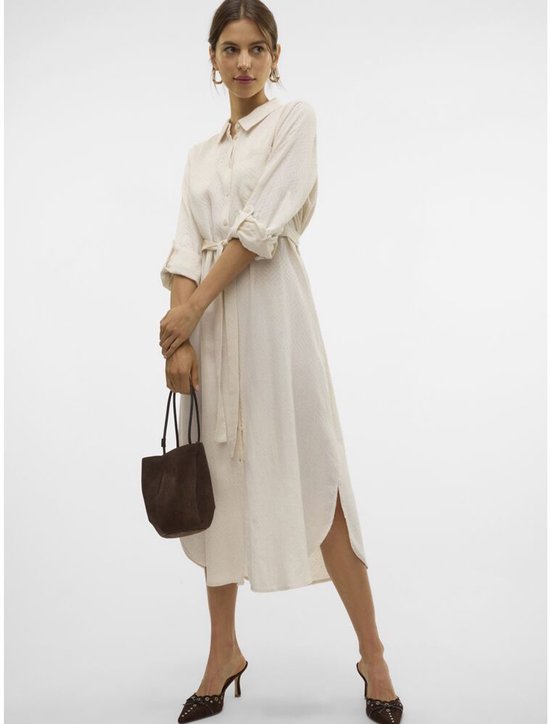 Mannequin portant une robe chemise crème avec ceinture à nouer et mules en daim marron.