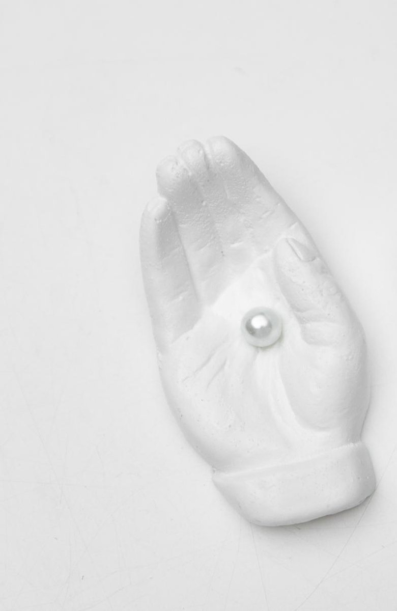 Beeld hand met parel wit