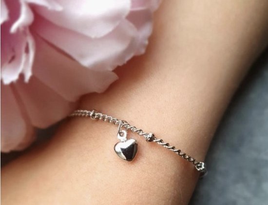 Zilverkleurige armband met een hartvormige bedel aan een fijne schakelketting met kleine pareltjes.