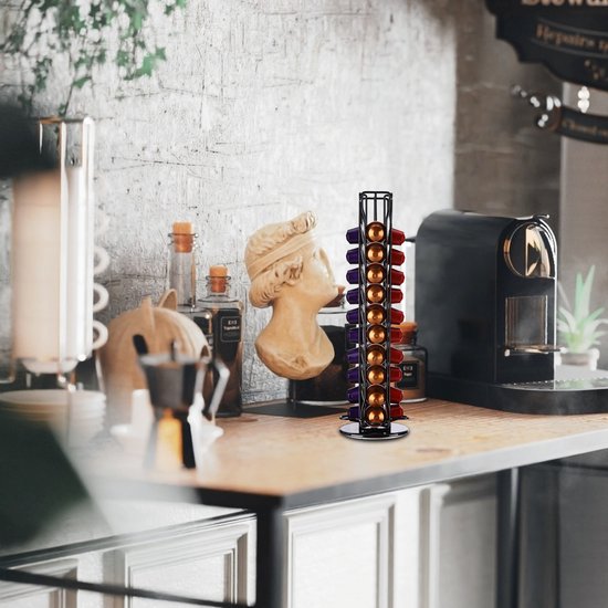Zwarte capsulehouder gevuld met rode, gouden en paarse Nespresso cups op een aanrecht.