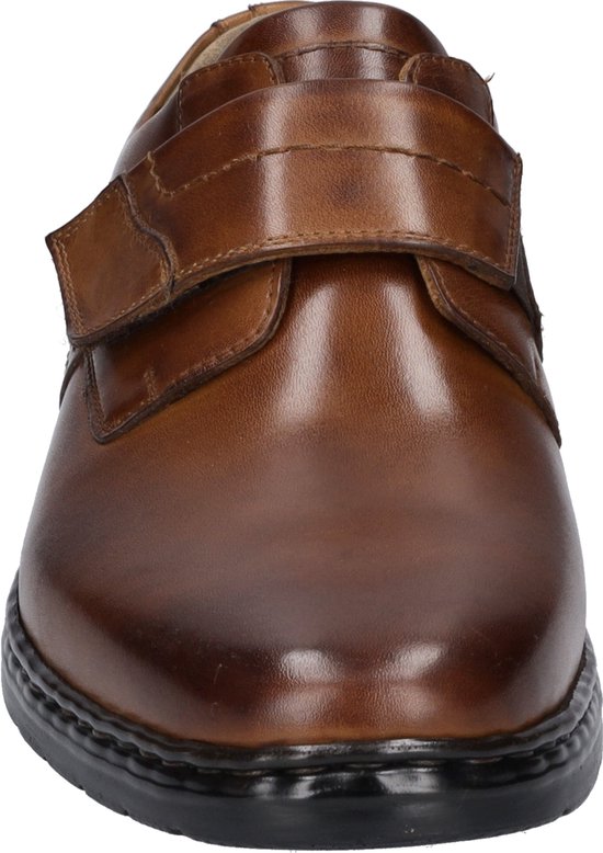 Voorkant van een bruine leren schoen met klittenbandsluiting en een zwarte zool.