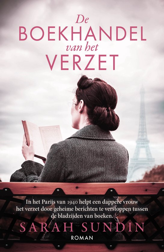 Vrouw met bril en opgestoken haar leest een boek op een bankje met de Eiffeltoren op de achtergrond.