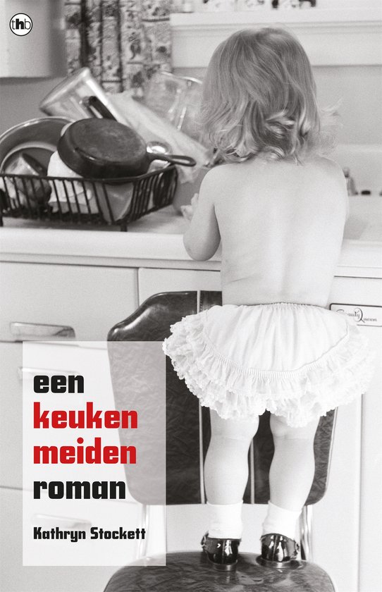 Een meisje met een witte tule rok staat op een krukje in de keuken.
