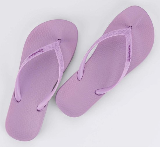 Lichtpaarse Ipanema teenslippers met logo op de bandjes, plat op een witte achtergrond.