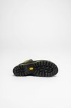 Onderkant van een groene bergschoen met zwarte Vibram zool met grof profiel.