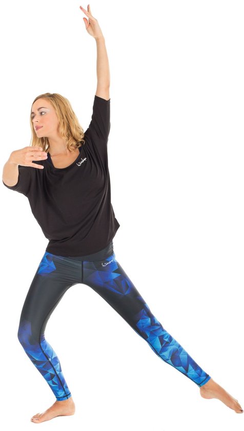 Model in een zwarte top en legging met blauw geometrisch veelhoekig patroon.