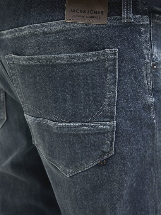 Detail van de achterzak van een donkere jeans met kenmerkende stiksels.