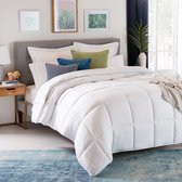 Wit vierseizoenen dekbed op een grijs bed met een beige plaid en decoratieve kussens.