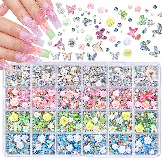 Hand met lange, roze en witte ombre nagels versierd met parels en strikken, omringd door losse nail art decoraties zoals rozen en vlinders.