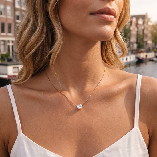 Vrouw met gouden ketting met hartvormige zirkonia hanger.