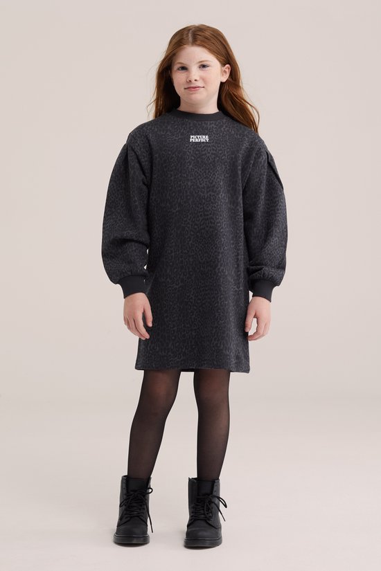 Meisje in donkergrijs oversized sweat jurkje met luipaardprint, pofmouwen, zwarte panty en laarsjes.