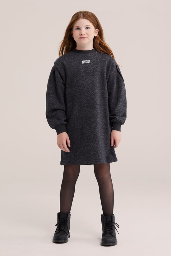 Model draagt een grijze, oversized sweatjurk met luipaardprint, pofmouwen, zwarte panty en veterschoenen.