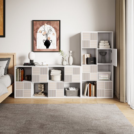 Witte kast in slaapkamer met spullen. Sommige vakken hebben een patroon van verticale ribbels. Deuren zijn deels open.