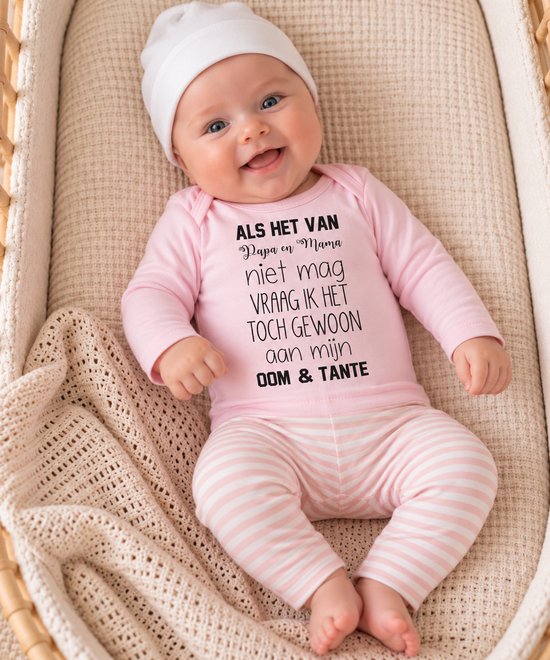 Baby in roze romper met tekst over oom en tante, gestreepte broek en wit mutsje in een wieg.