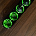 Zwarte Shelly Power Strip 4 Gen4 stekkerdoos met felgroen verlichte stopcontacten op een houten ondergrond.