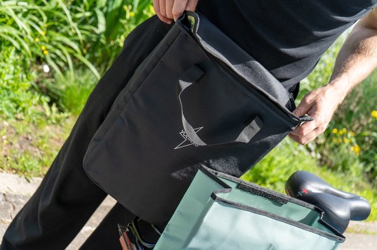 Zwarte Voltano koeltas met handvatten, deels in een groen fietstascompartiment geplaatst.