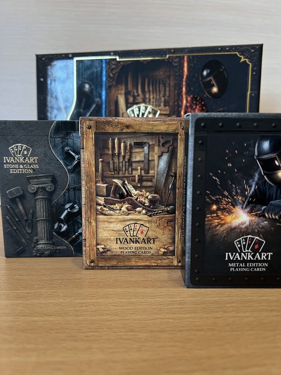 Bovenaanzicht van de gestapelde Ivankart-kaartspellen: Metal, Wood en Stone & Glass edition.