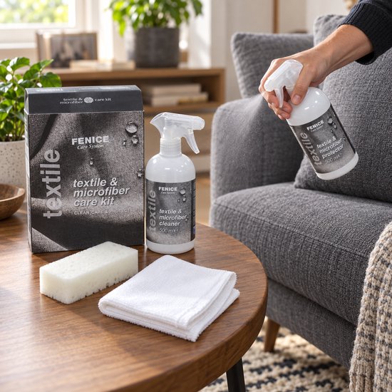 Iemand gebruikt een Fenice textiel- en microvezelverzorgingsspray op een grijze stoffen bank.