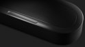 Zwarte Sonos soundbar met volumeknoppen (+ en -) bovenop en een geperforeerd rooster.